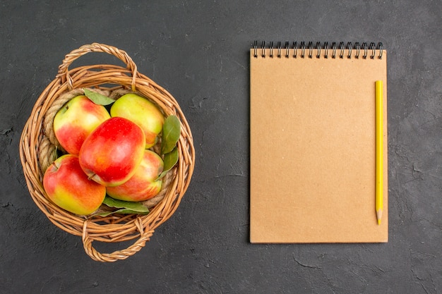 Foto gratuita vista dall'alto mele fresche frutti maturi all'interno del cesto su pavimento grigio frutta matura fresca