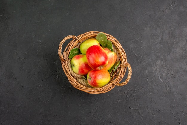 회색 테이블에 있는 바구니 안에 있는 신선한 사과 잘 익은 과일을 볼 수 있습니다.