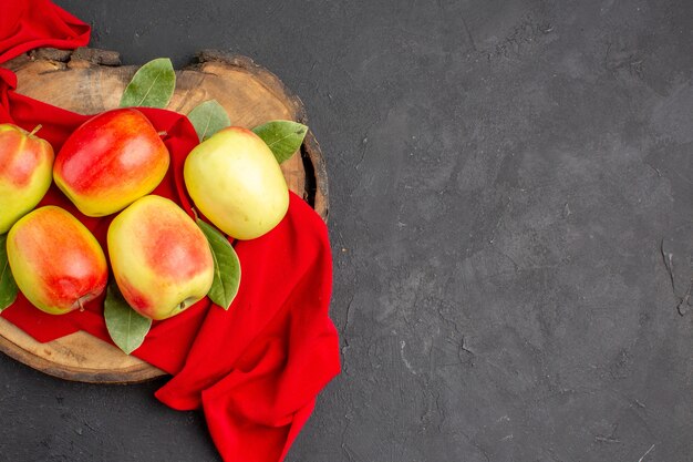 Top view fresh apples ripe fruits on red tissue and grey table ripe fruit fresh