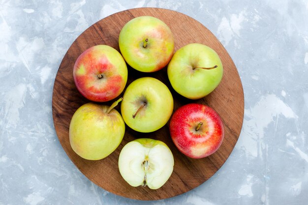真っ白な机の上に新鮮なリンゴの熟したまろやかな果実の上面図