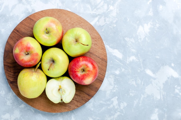 Top view fresh apples ripe mellow fruits on the light-white desk