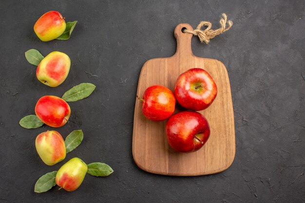 Top view fresh apples with green leaves on dark table mellow  fresh ripe