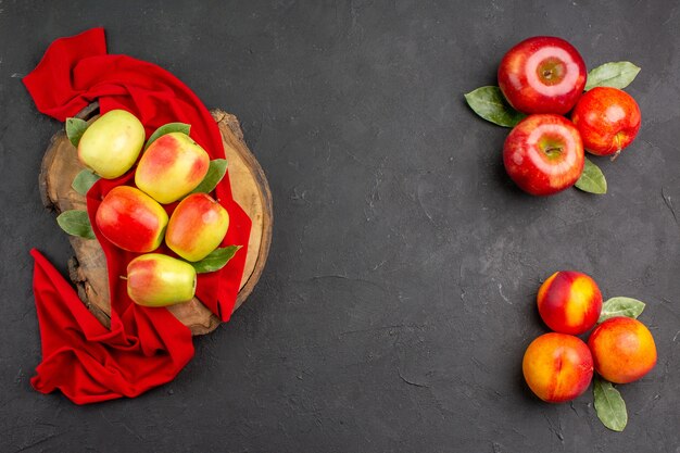 Top view fresh apples with peaches on dark-grey table fresh ripe fruits color 