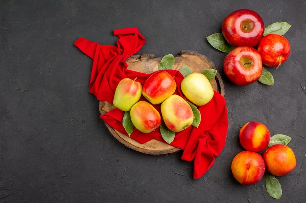 짙은 회색 테이블에 잘 익은 과일 색에 복숭아가 있는 상위 뷰 신선한 사과