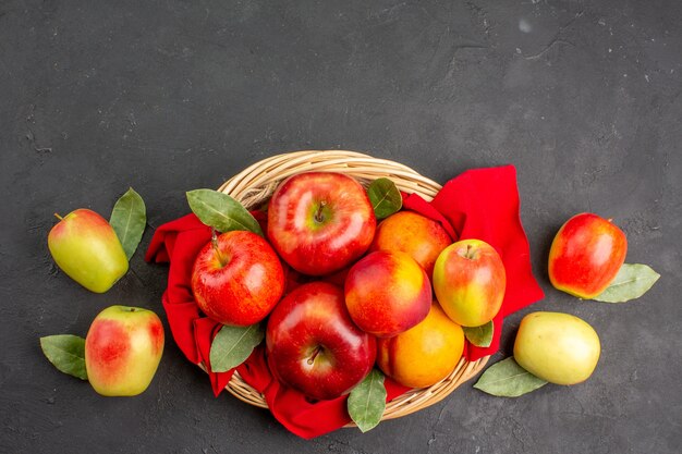 Вид сверху свежие яблоки с персиками на темном столе спелых фруктов, спелых соков