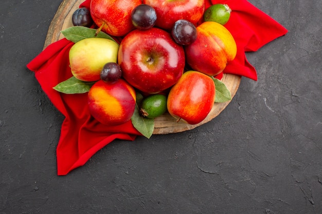 Foto gratuita vista dall'alto mele fresche con pesche e prugne sul pavimento scuro succo maturo di alberi da frutto