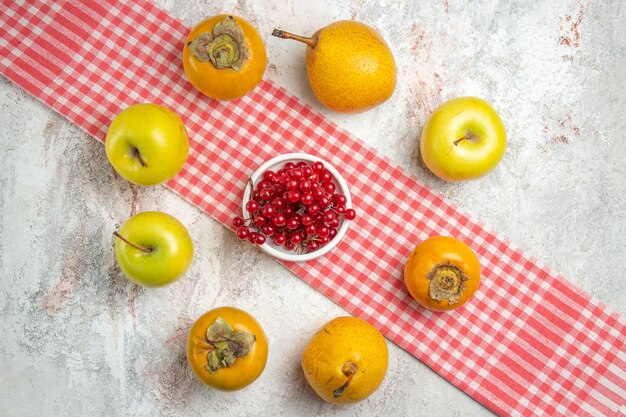 Vista dall'alto mele fresche con cachi sulla salute dell'albero di bacche di frutta da tavola bianca