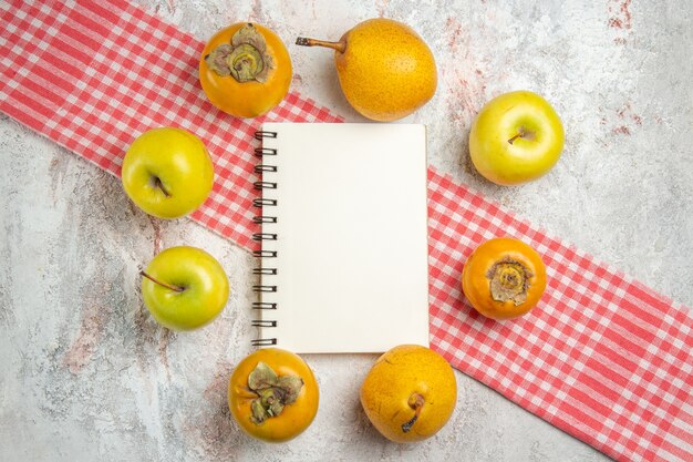 Top view fresh apples with persimmons on white table fruit berry tree health