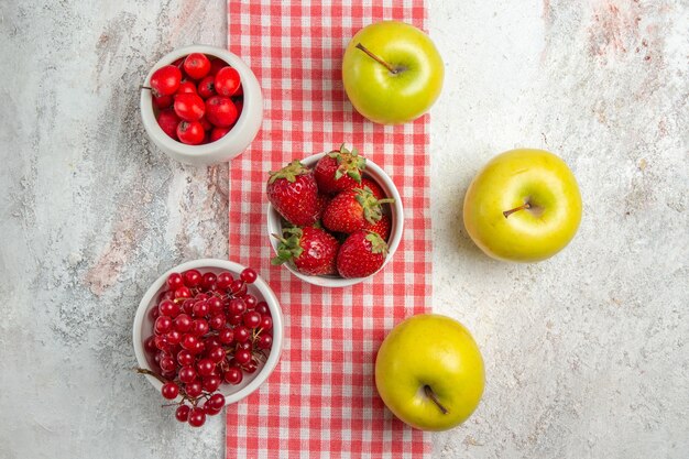 上面図白いテーブルフルーツベリー色の木に赤いベリーと新鮮なリンゴ