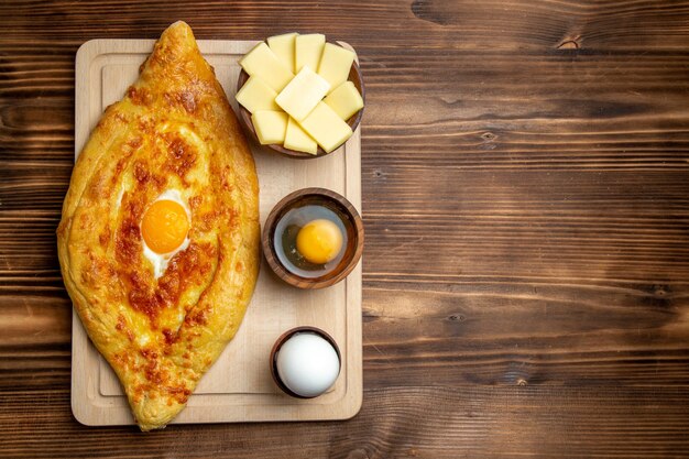 Top view fresh baked bread with cooked egg on the brown wooden desk bread dough meal bun breakfast egg food