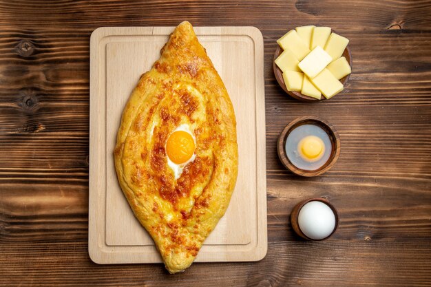 Top view fresh baked bread with cooked egg on brown wooden desk bread dough meal bun food breakfast egg