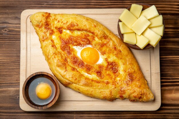 Top view fresh baked bread with cooked egg on brown wooden floor dough meal bun breakfast eggs food