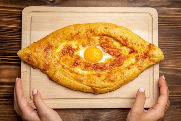 Free photo top view fresh baked bread with cooked egg on wooden desk bread dough meal bun food breakfast egg