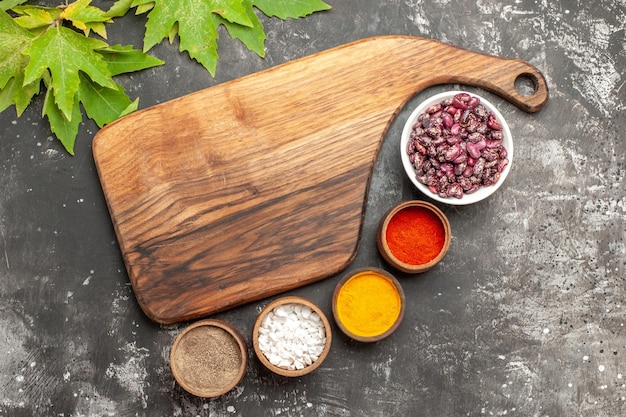 Free photo top view fresh beans with different seasonings on dark surface