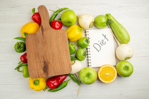 Top view fresh bell-peppers with apples and oranges on white background color photo salad healthy life ripe diet