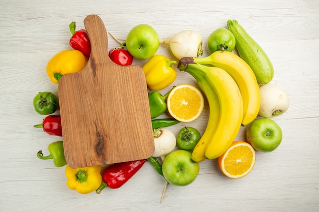 Top view fresh bell-peppers with bananas apples and orange on white background salad healthy life photo ripe color diet