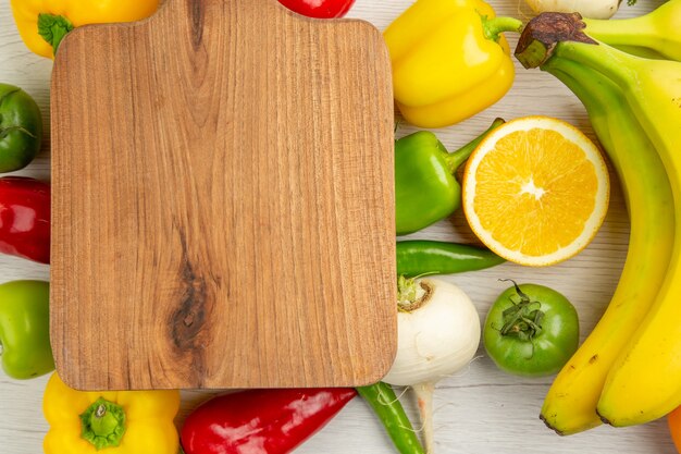 Top view fresh bell-peppers with bananas and orange on white background salad healthy life photo color diet