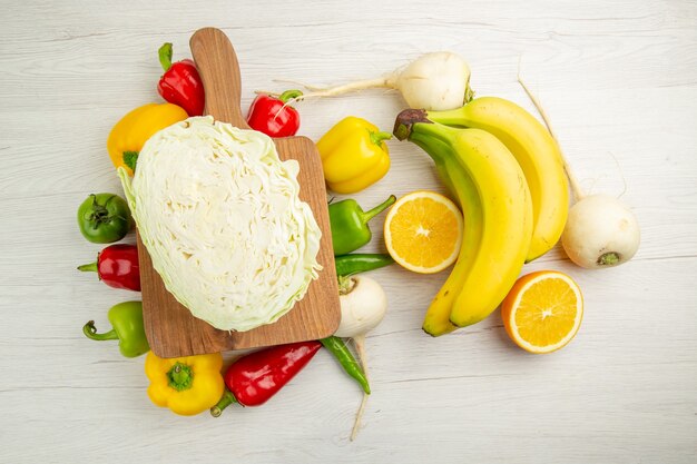 Вид сверху свежий болгарский перец с бананами и апельсином на белом фоне салат здоровый образ жизни фото спелый цвет диета
