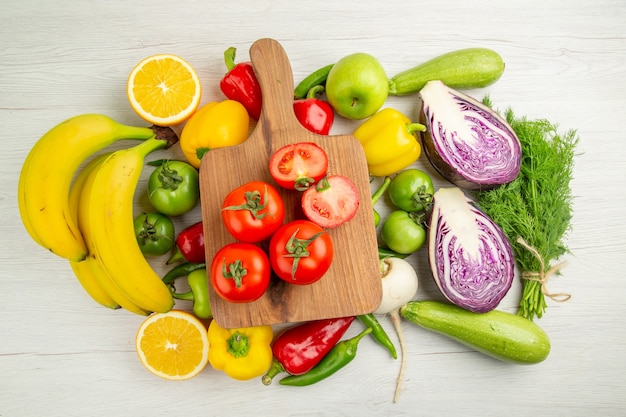 Top view fresh bell-peppers with bananas tomatoes and red cabbage on white background color diet ripe healthy life salad photo