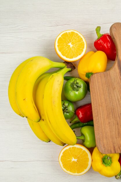 Top view fresh bell-peppers with bananas on white background ripe color healthy life diet salad photo