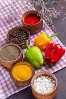 Free photo top view fresh bell-peppers with different seasonings on grey surface meal food ingredient veegtable