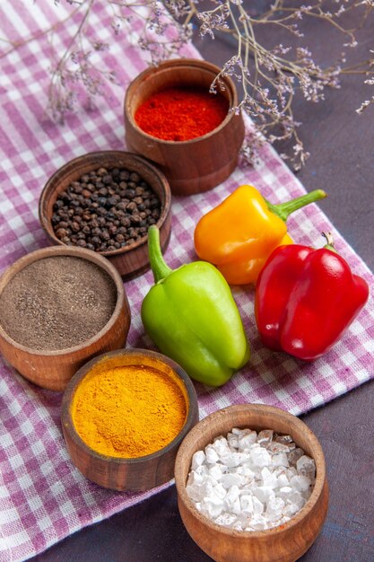 Top view fresh bell-peppers with different seasonings on grey surface meal food ingredient veegtable