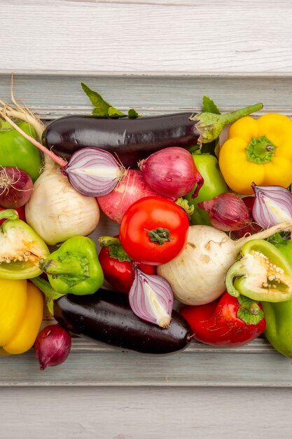 Top view fresh bell-peppers with radish and onions on the white table