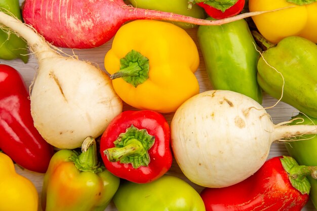 Top view fresh bell-peppers with radish on a white table