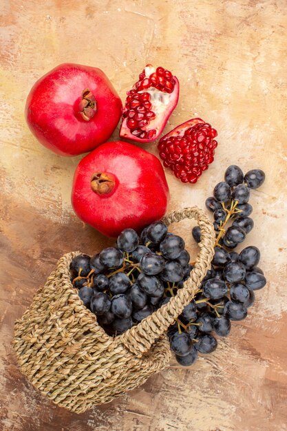 Top view fresh black grapes with pomegranates on light background