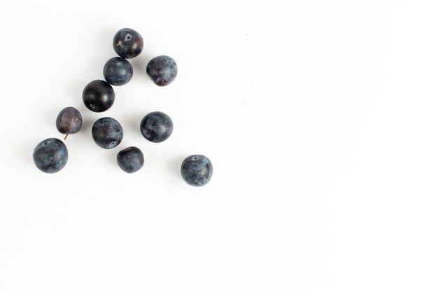 Top view fresh blackthorns sour and dark fruits on the desk background