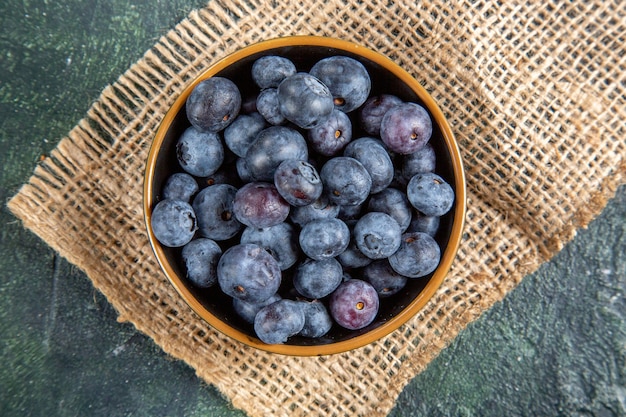 Top view fresh blueberries inside plate dark surface