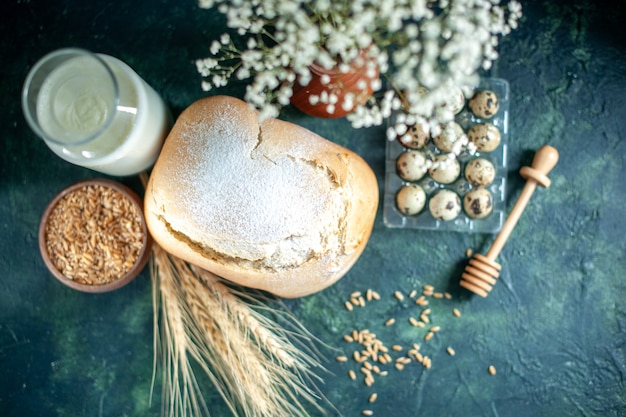 Top view fresh bread with milk and eggs on dark-blue surface