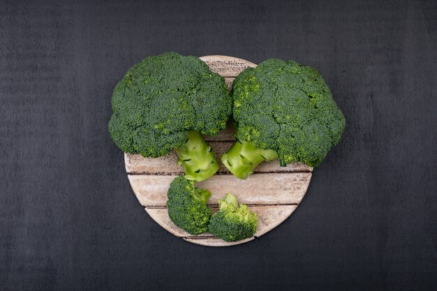 Top view fresh broccoli on wooden cutting board