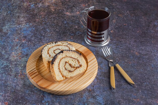 Top view of fresh cake rolls with cup of tea on rustic