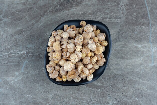 Top view of fresh candies in black bowl.