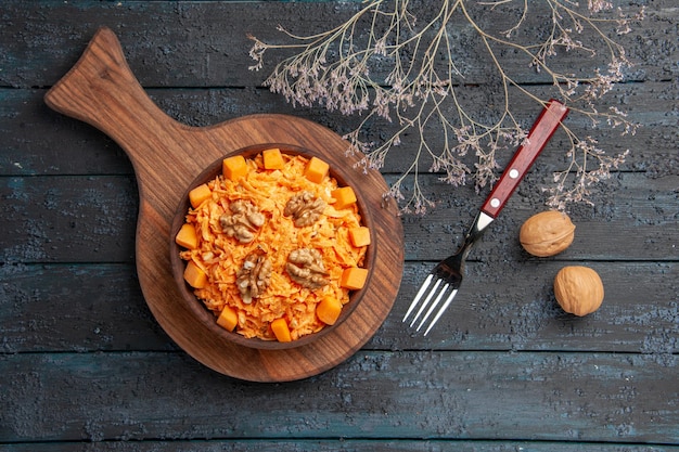 Foto gratuita vista dall'alto insalata di carote fresche grattugiate con noci su insalata di noci di colore dietetico scuro da scrivania