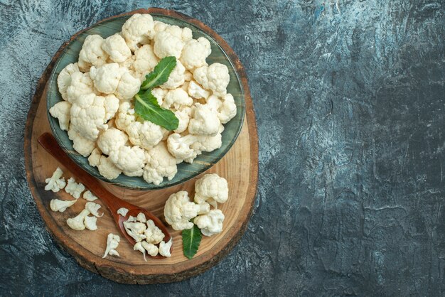 Top view fresh cauliflower inside plate on light-grey table