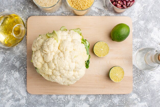 Top view of fresh cauliflower with lemon slices on the wooden rustic grey surface