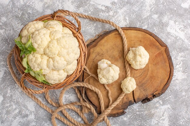 Top view of fresh cauliflower with ropes on white-light surface