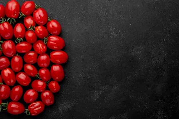 Top view of fresh cherry tomatoes on black background with copy space