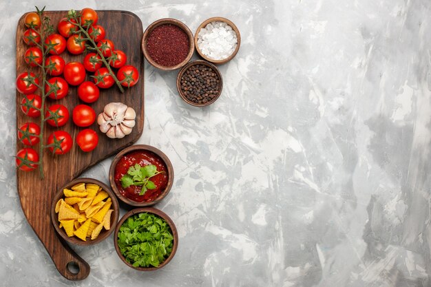 Top view fresh cherry tomatoes with seasonings on light white surface