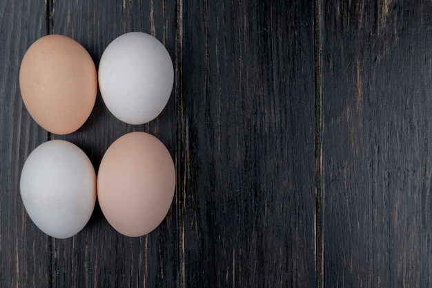 Top view of fresh chicken eggs on a wooden background with copy space