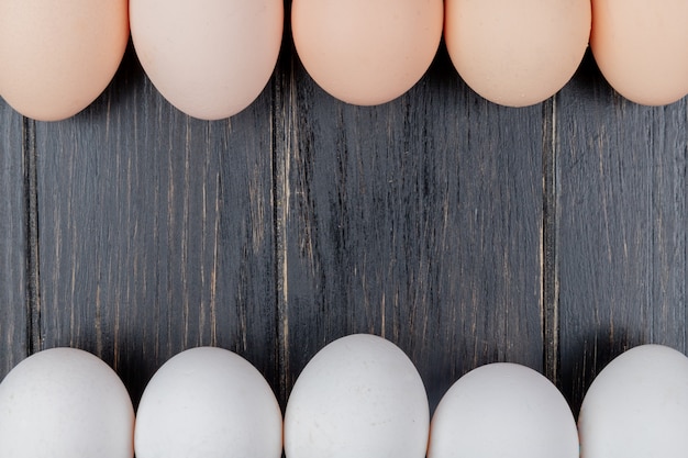 Top view of fresh chicken eggs on a wooden background with copy space