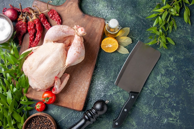 Top view fresh chicken with red tomatoes on dark blue surface