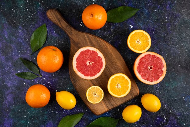 木の板の葉と新鮮な柑橘系の果物の上面図。