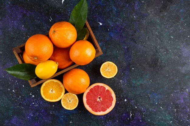 木製のバスケットまたは地面に新鮮な柑橘系の果物の上面図。 。