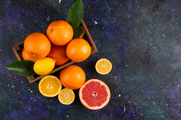 Top view of Fresh citrus fruits in wooden basket or on ground. .