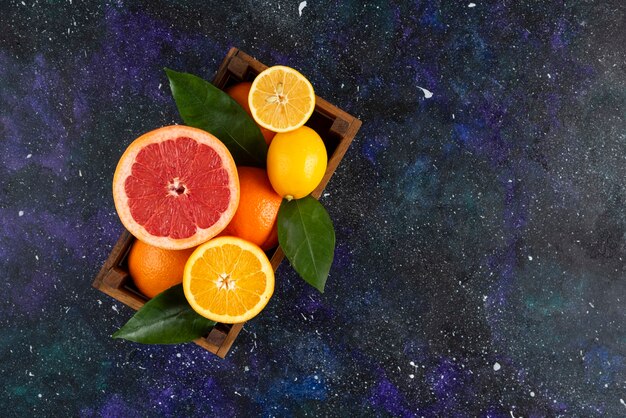 木製のバスケットに新鮮な柑橘系の果物の上面図。