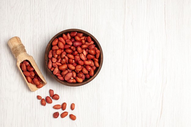 Top view fresh clean peanuts inside plate on white desk nuts many tree plant shell snack