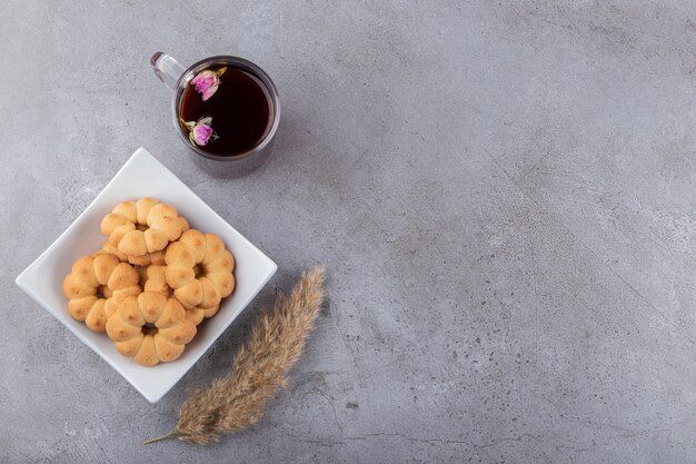 Top view of fresh cookies on white plate and fragrant tea